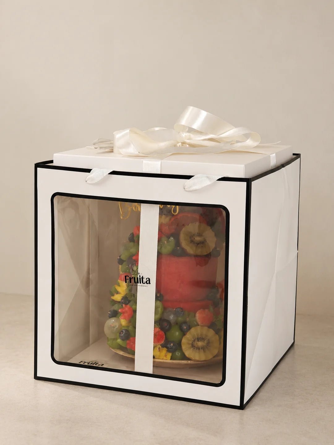 A La Fruita fruit cake in its presentation box and outer carrier